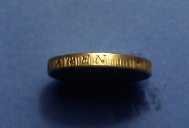 Edge of a 1996 dated one-pound counterfeit. It shows some of the millings have not been made.